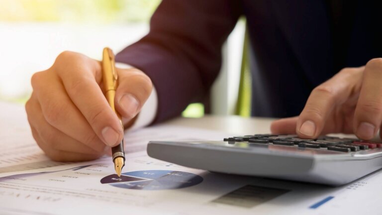 businessman using calculator and analyzing charts