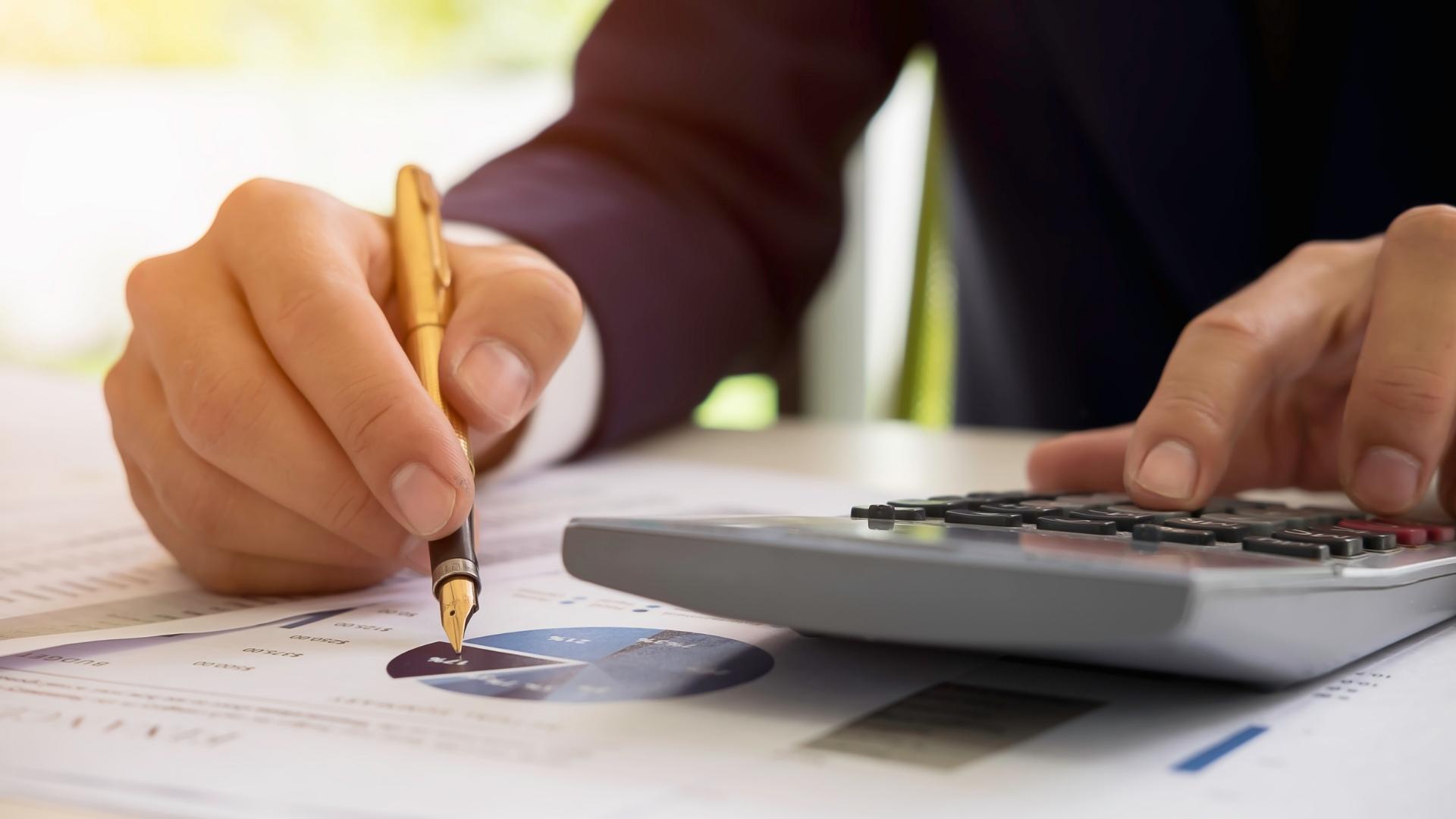 businessman using calculator and analyzing costs