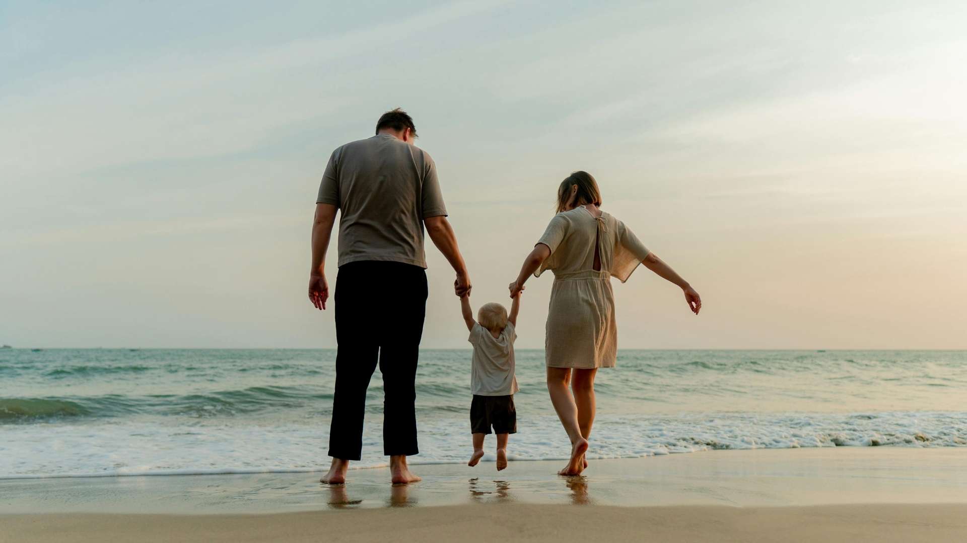 family walking together on seaside beach