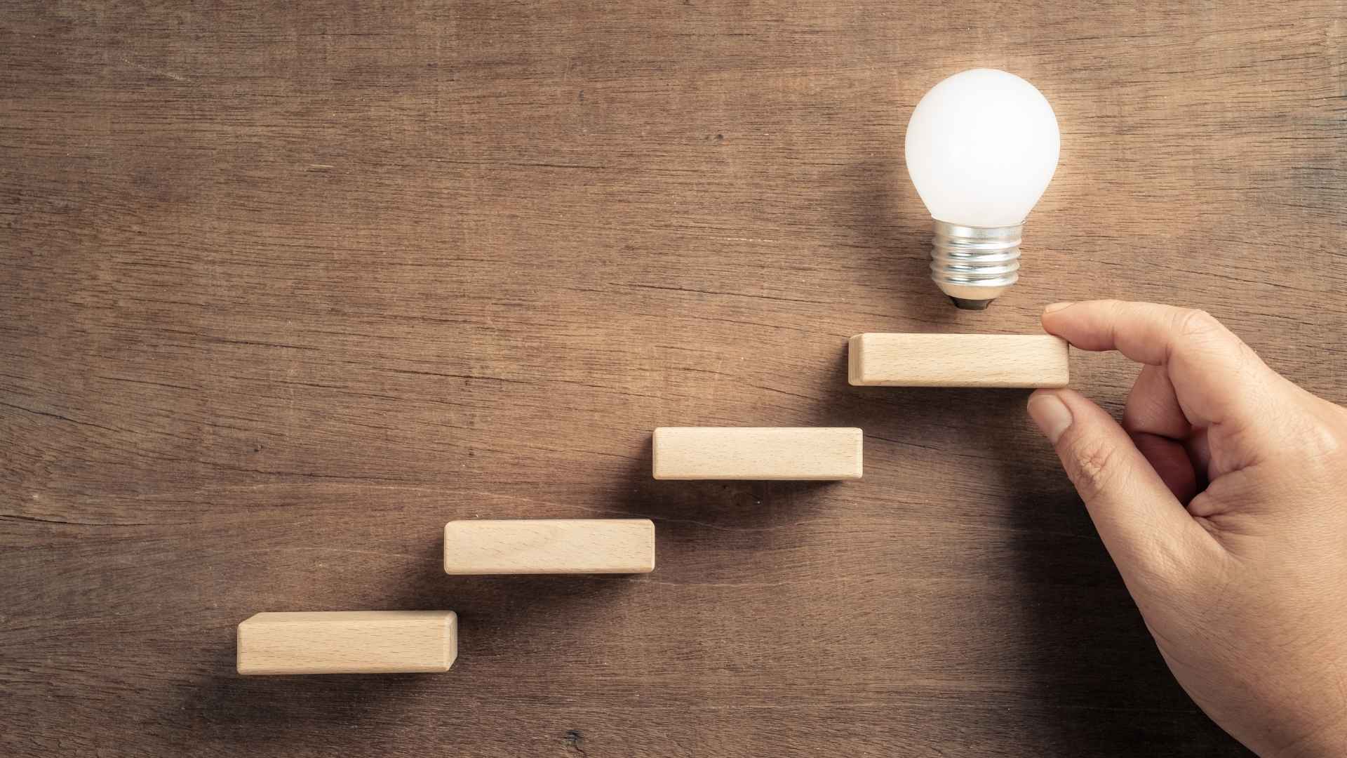 hand arrange wood blocks with glowing light bulb