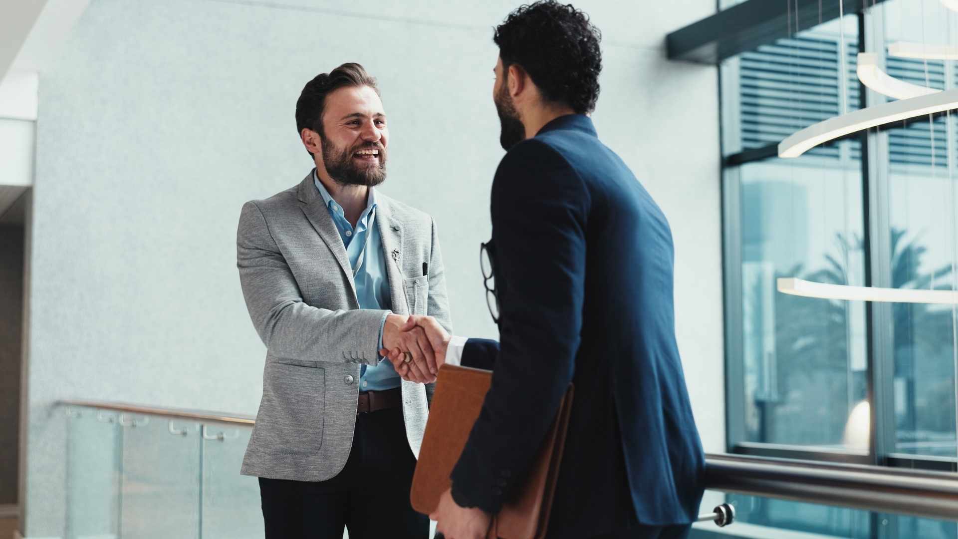 handshake and meeting with business people at window in office for partnership