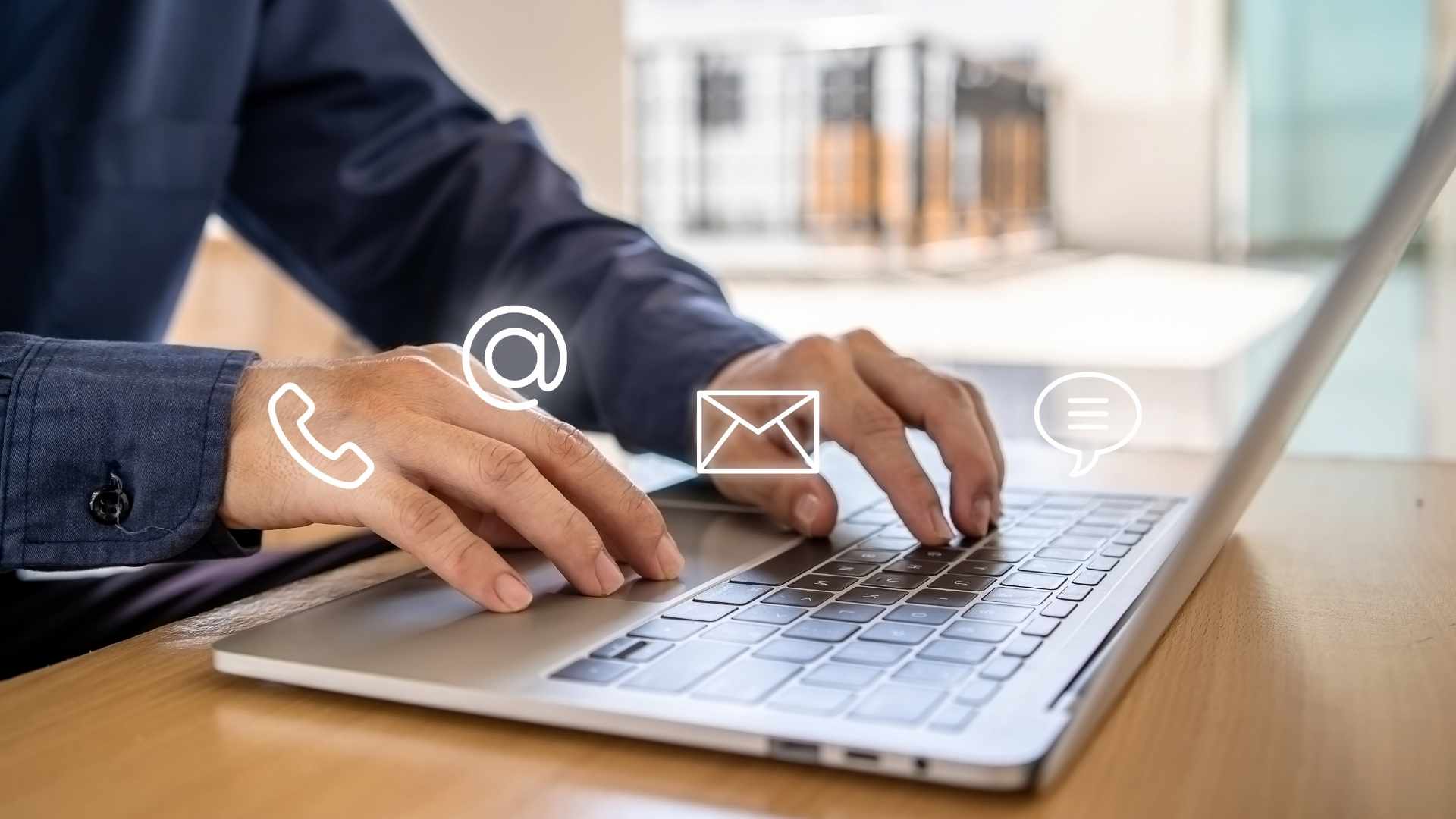 man typing in the laptop with floating icons