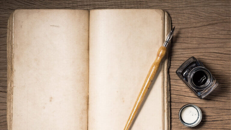 opened blank book with pen and ink on the side