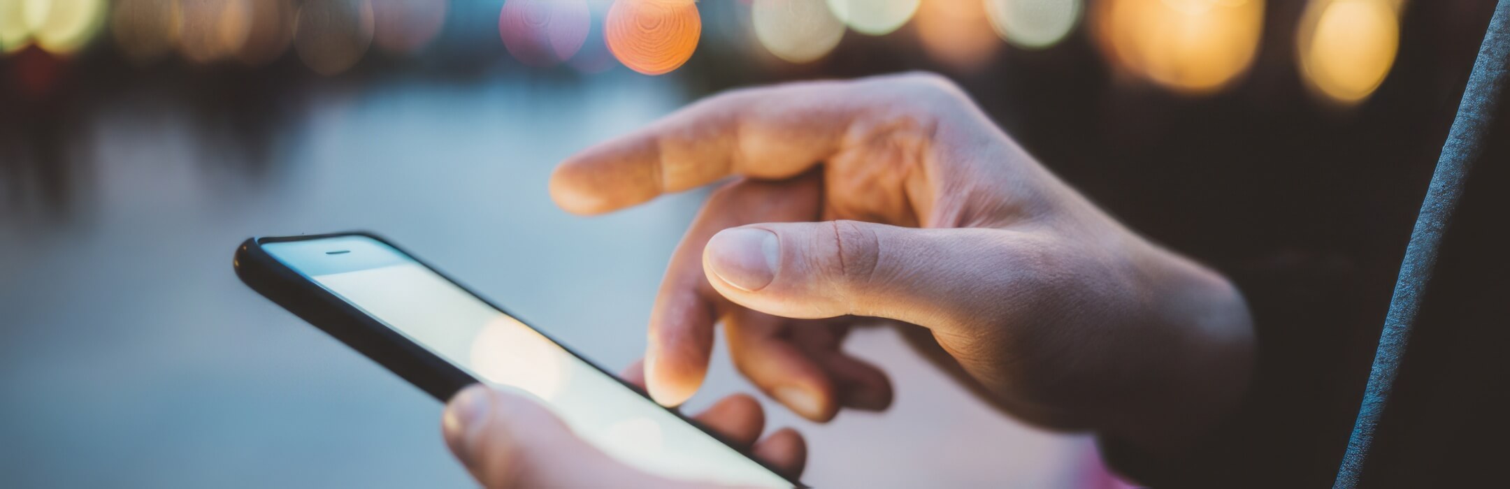person holding their phone in a city
