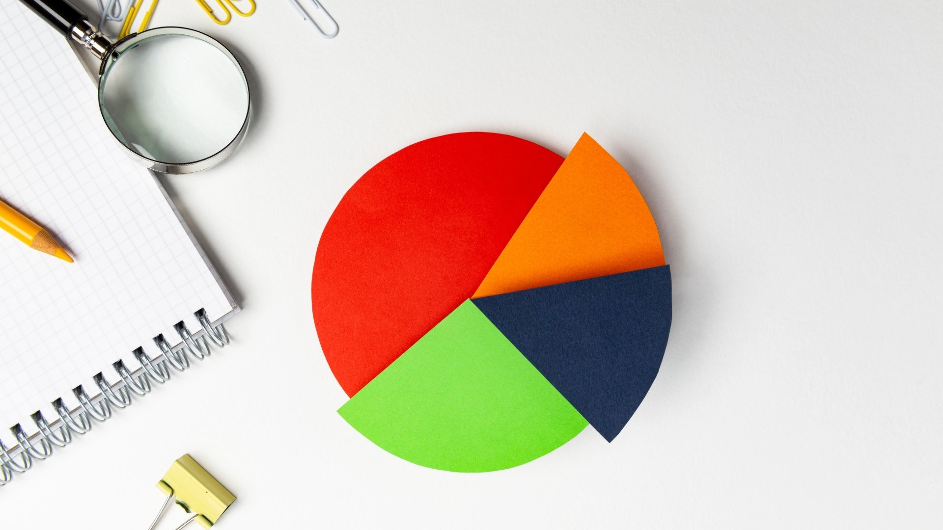 pie chart in white background with notebooks and pen