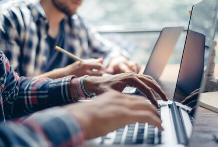Two people using laptop