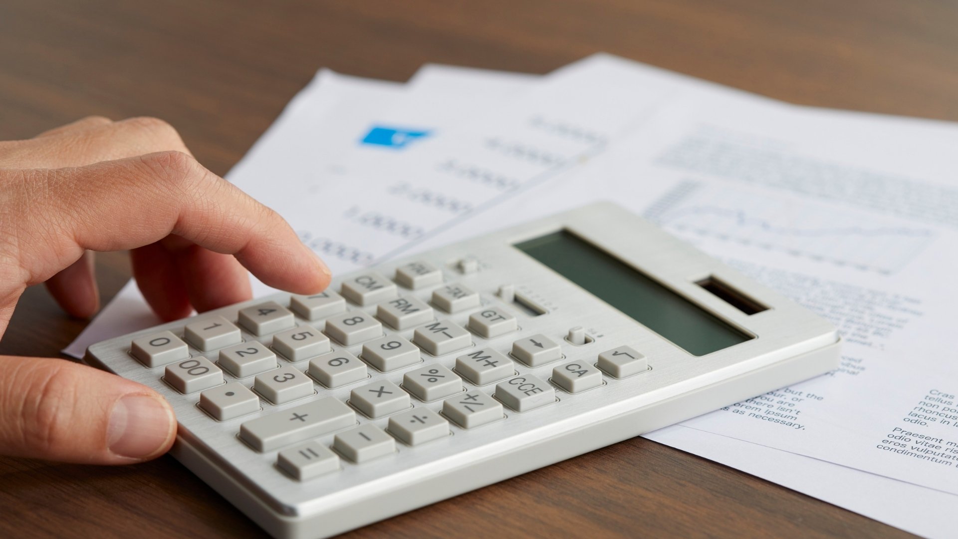 white mini calculator being used for computing marketing budget