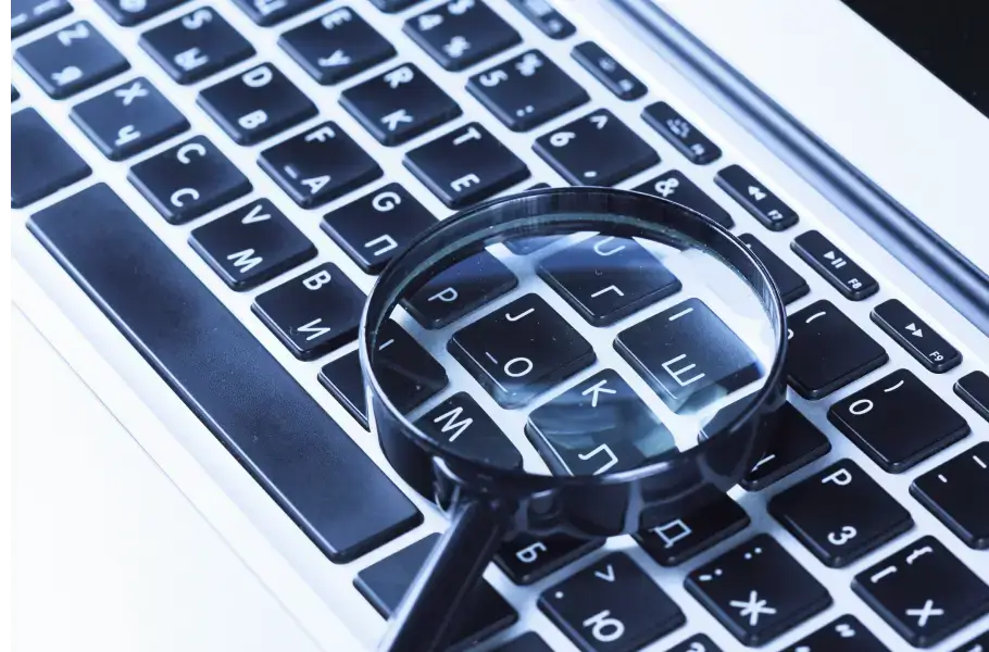 Magnifying glass on a laptop keyboard with Cyrillic letters