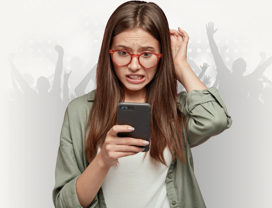 Young woman with red glasses looking stressed while checking her phone